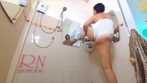 Nice lady in the shower room rubs cosmetic massage lotion oil on her beautiful legs. cam 2-2