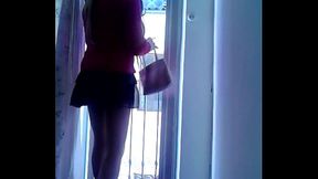 Lili cd sumisa con tacones rojos se asoma al balc&oacute_n para recibir un cliente