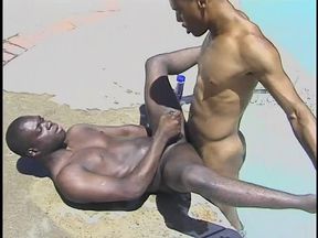 Black stud bends over to get a wet rimming in the pool