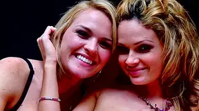 Blonde lesbians in black lingerie enjoy sex on a bed