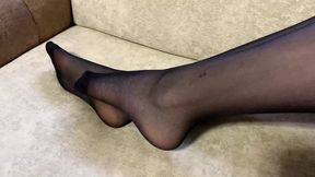 Girl in black nylon tights caresses her long legs