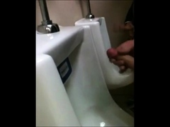 two slim dicks getting wanked at the urinals