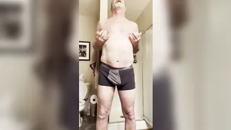 Hairy daddy bear strips, strokes his big cock and showers solo
