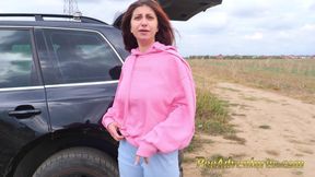 Hipster girl pee next to the wheel of the car