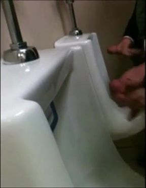 two slim dicks getting wanked at the urinals