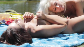 Bombshell lesbian girls pleasure each other along a lake