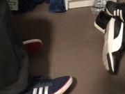 Male shoeplay in striped socks and different sneakers and watching a movie