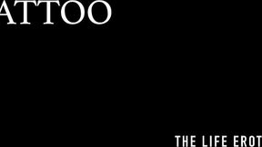 ”Tattooed girl Foxy Sanie rubs her shaved beaver while being inked”