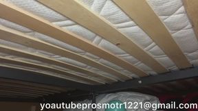Nastya walks and tramples, jumps, on a large bed and a new mattress, pushing through the slats, they creak and bend under her weight, view from below