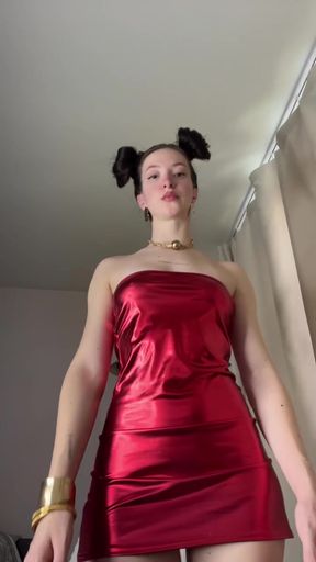 Redhead in a metallic mini dress with space buns poses sexily