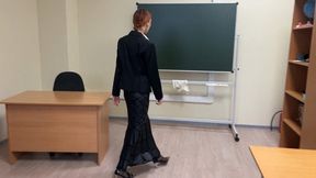 The teacher at school is preparing for the lesson and checking her notebooks, she is a little bored, so she plays with shoes sitting right in the classroom