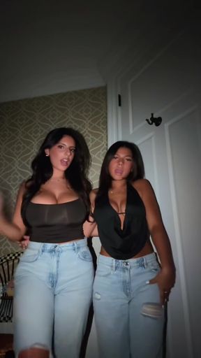Woman in black tank top and blue jeans, waving with other woman
