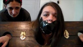 Thieving roommate locked in the stockade and gagged with her own panties!