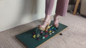 Giantess Lily Kink toy car crush of many tiny cars in big chunky heels high left view