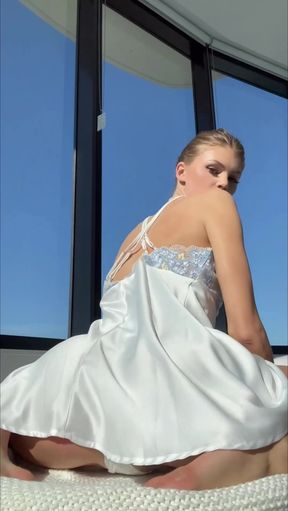 Blonde woman in white dress posing