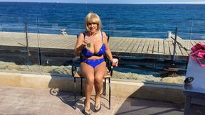 Smoking by the ocean in blue bikini