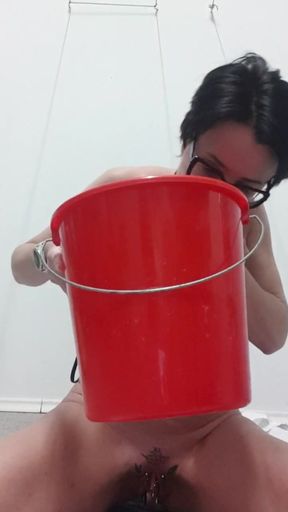 Milf Julie sits on bucket and squirts