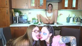 while two perverted lesbians kiss hard, the third one jerks off while sitting on the kitchen stove