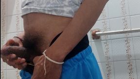 Man with a big cock masturbates in a bathroom