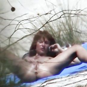 Redhead beauty dildoing pussy on the sandy beach