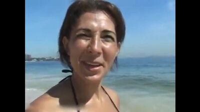 Slutty cougar is having sex with a guy she just met on the beach
