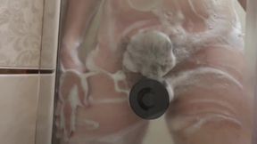 Pregnant milf in the lather in the shower masturbates with a dildo. Rubber dick fucks hairy pussy.