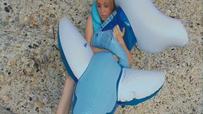 Alla blows off a blue transparent inflatable whale on the beach and wears an inflatable vest!!!