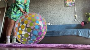 girl in dress and socks play with beachball