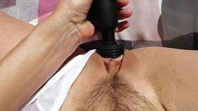 Petite Asian sunbather enjoys a squirting session in nature