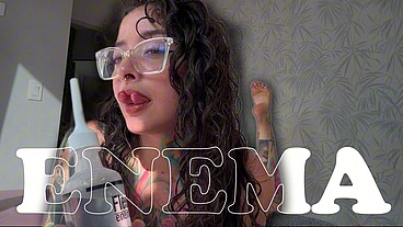 A girl with a split tongue gives herself an enema on camera.