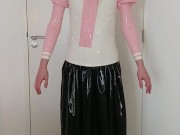 Putting on pink frilly latex blouse over long rubber skirt, maid stockings, panties, layers