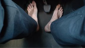 Riding a car, pedal pumping barefoot - soles above the hard pedals