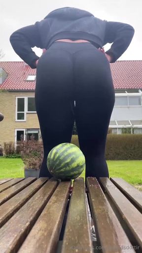 Woman sitting on bench with watermelon