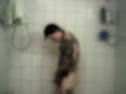 Homme bi et tattoué prend une longue douche chaude