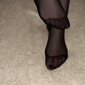 Girl shows her sexy feet in black nylon pantyhose