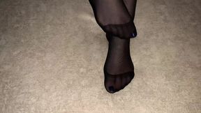 Girl shows her sexy feet in black nylon pantyhose