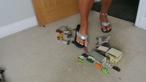 Nikkichick crushes buildings & many small cars in flip flops with painted toe nails toy cars crush low right view