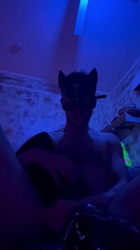 Putting leather boots on in a leather mask