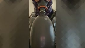 Prêt pour un orgasme avec masque à gaz et sac. Equipement complété par un imperméable brillant en vinyle.