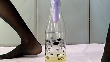 Adult with big tits pisses in a bottle through a funnel
