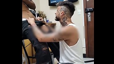 De joelhos na frente do cliente medindo o local da tatuagem