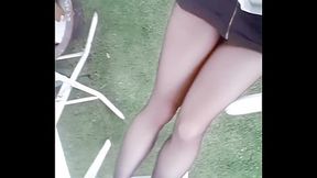 Teen Asian beauty in tight outfit and black hose strolls through garden