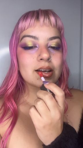 Brunette babe applies lipstick with makeup