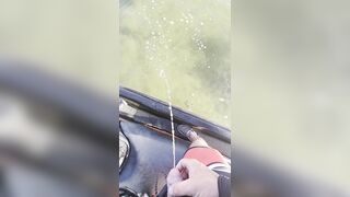 Pissing off the side of a jet ski into the water urinating outdoors
