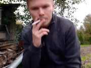 Russian guy smokes a cigarette in dirty shoes and spits