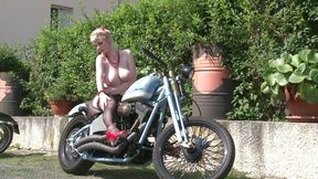 Superb blonde babe with huge boobs is showing her an amazing body outdoors