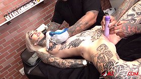 Sascha plays with Amber Luke while she gets tattooed