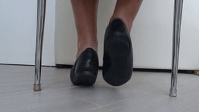 Play of shoes and bare feet under the chair c