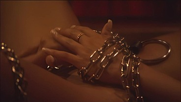 This masked brunette is chained to the bed and awaiting orders