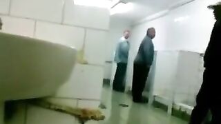 Watch this guy give a steamy handjob and pierce his friend's ass in a public rest room